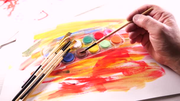 Πινέλα και χρώματα watercolor σε κίνηση στο τραπέζι - Πλάνα, βίντεο