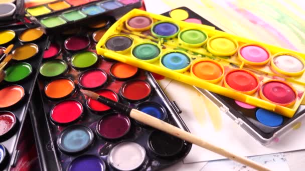 Paint brushes and watercolor paints in motion on the table - Footage, Video