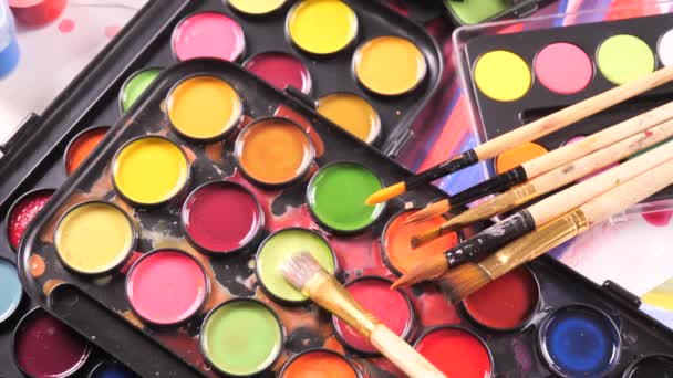 Štětce a akvarel barvy v pohybu na stole - Záběry, video