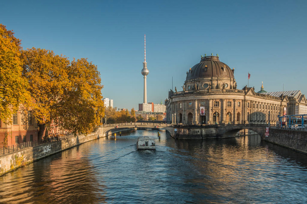 Paisaje urbano de Berlín con isla museo y el río Spree en otoño. un barco está navegando en el río. En el fondo, la torre de televisión es visible en el cielo azul en el día soleado
 - Foto, imagen