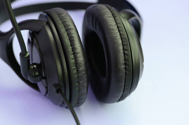 Black headphones lies on a colorful pastel violet background. Music listening concept - Photo, Image