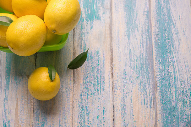 Желтый лимон и листья на старой доске
 - Фото, изображение