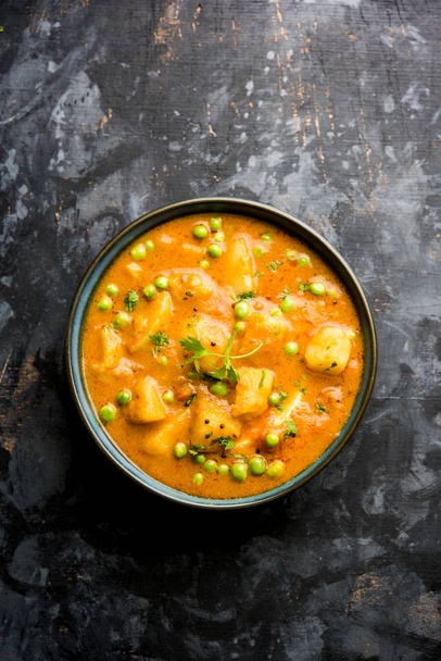 Indian Aloo curry Mutter - ziemniaki i groszek zanurzone w sosie pomidorowym cebula i przyozdobionym z liści kolendry. Serwowane w Karahi/kadhai lub patelni lub miski. Selektywny fokus - Zdjęcie, obraz