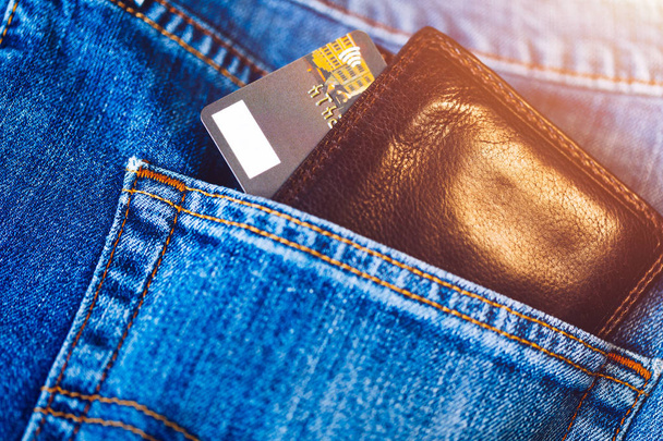 Tarjeta de crédito en cartera en bolsillo de jeans, primer plano. Primer plano de billetera y tarjeta de crédito en el bolsillo de pantalones vaqueros
.  - Foto, imagen