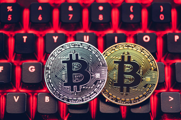 Bitcoin on compuer keyboard in background, symbol of electronic virtual money and mining cryptocurrency concept. Coin crypto currency bitcoin lies on the keyboard. Bitcoin on keyboard. - Photo, Image