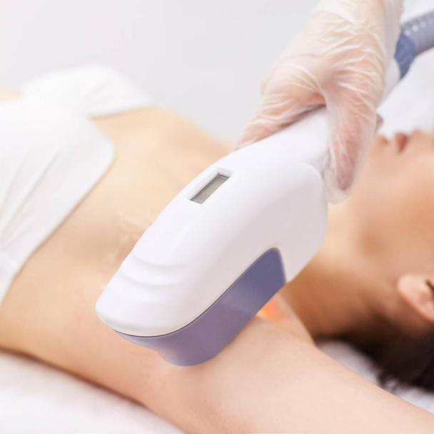 Medical beauty laser cosmeology procedure. Young female at salon. Professional doctor. Woman skincare technology. Hair removal. - Foto, Imagen