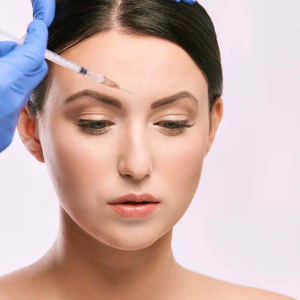 Face needle injection. Young woman cosmetology procedure. Doctor gloves. - Foto, imagen