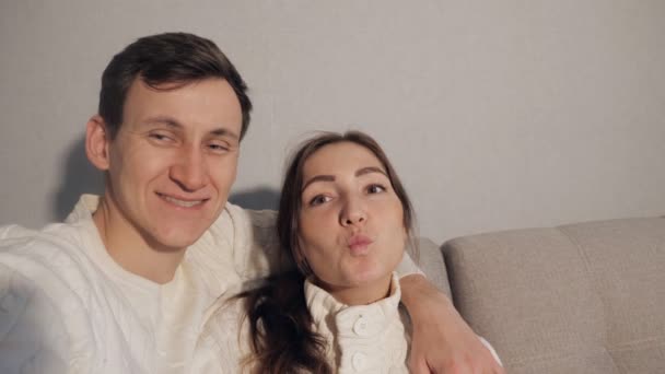 Νεαρό ζευγάρι μαζί στο σπίτι το σαββατοκύριακο λήψη selfie φωτογραφίες χαρούμενα - Πλάνα, βίντεο