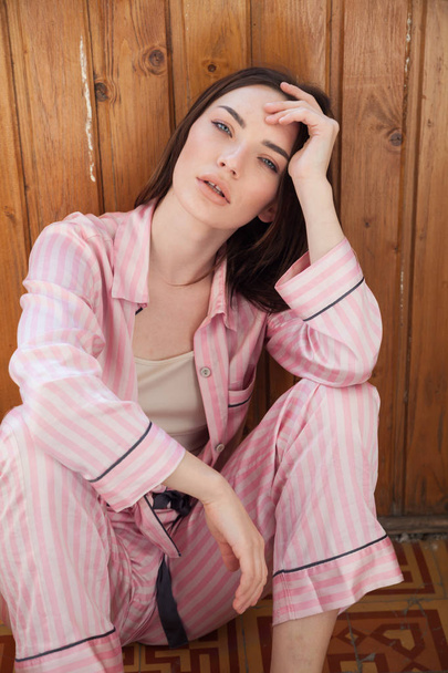 Žena v růžové pyžamo módní portrét ložnici - Fotografie, Obrázek