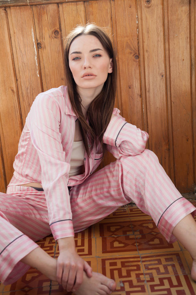 Žena v růžové pyžamo módní portrét ložnici - Fotografie, Obrázek