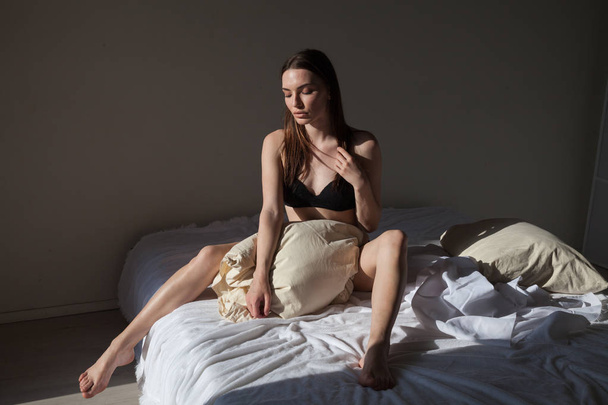 mooie vrouw in ondergoed in de slaapkamer op het bed in de ochtend - Foto, afbeelding
