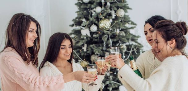 Portrait schöner Frauen amüsiert sich im weihnachtlichen Interieur mit Champagner - Foto, Bild