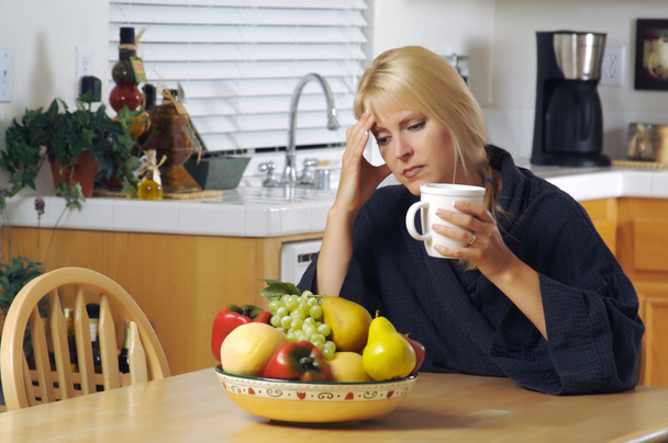 Stressaantunut nainen tilalla pää keittiössä
 - Valokuva, kuva