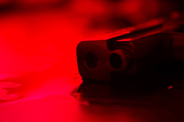 High contrast image of a bloody crime scene with gun on the floor - Φωτογραφία, εικόνα