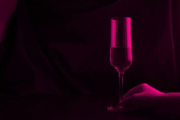 one glass in red light. copy space - Фото, изображение