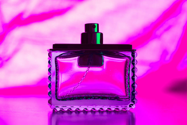 Parfümflasche auf dem Tisch. rosa Hintergrund - Foto, Bild