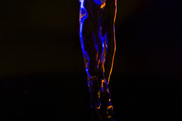 Κόκκινο και μπλε νέον φόντο από τη ροή του νερού. δεφοκεντρικός - Φωτογραφία, εικόνα