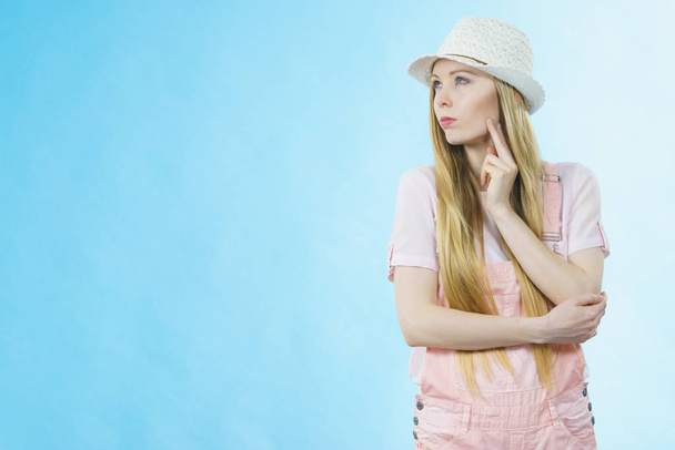 Cute teenage young woman ready for summer wearing pink outfit and sun hat thinking about something. - Foto, Imagem