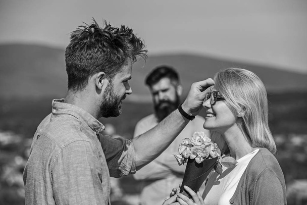 Couple in love dating while jealous husband fixedly watching on background. Unrequited love concept. Lovers meeting outdoor flirt romance relations. Couple romantic date lover present bouquet flowers - Fotoğraf, Görsel