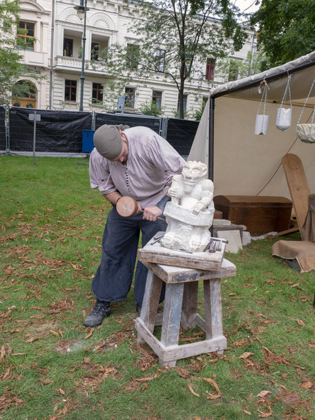 Magdeburg, Germany - 29.08.2014: Kaiser-Otto-Fest. Reconstruction of historical events of the city. Medieval crafts. Stonemason makes a figure of stone - Photo, Image