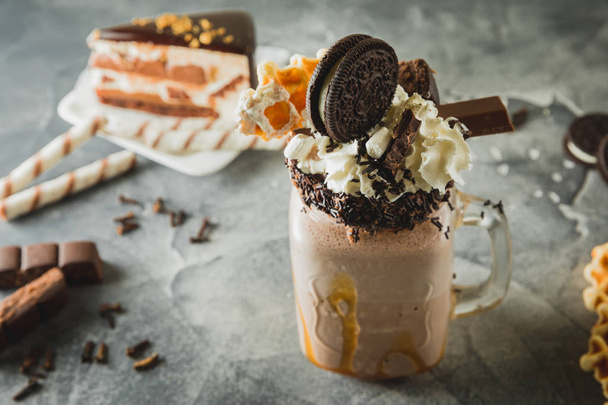 Sos, krema, kakao çerezleri damlama ile çikolatalı milkshake - Fotoğraf, Görsel