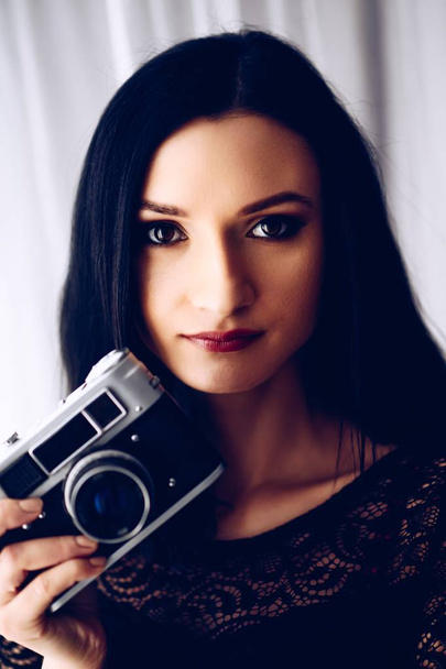 Mulher morena jovem tirando fotos com câmera de foto vintage antiga
 - Foto, Imagem