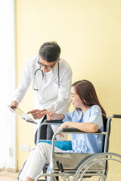 Asian female patient on wheelchair with senior doctor - Foto, Imagem