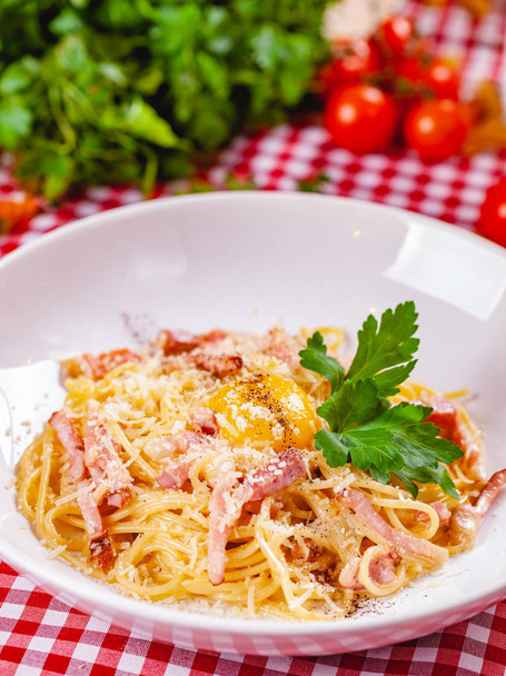 Spaghetti Carbonara with bacon, yolk and cheese on white plate. Close up - Фото, зображення