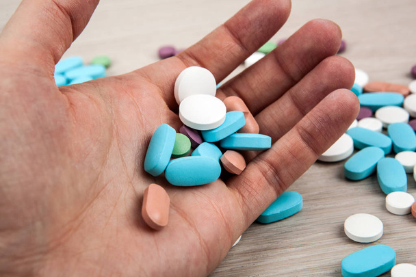 multi-colored medical pills in the human hand close up - Photo, Image