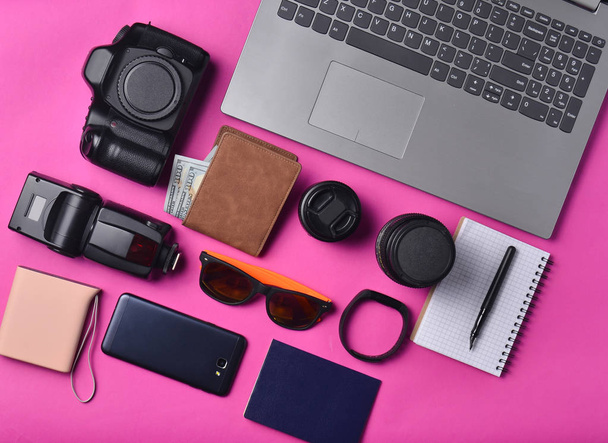 Equipment photographer,  laptop, purse with dollars,  smartphone, smart watch, passport, power bank, on yellow background. Freelance concept, gadgets for work and travel , objects, top view, flat la - Foto, Imagen