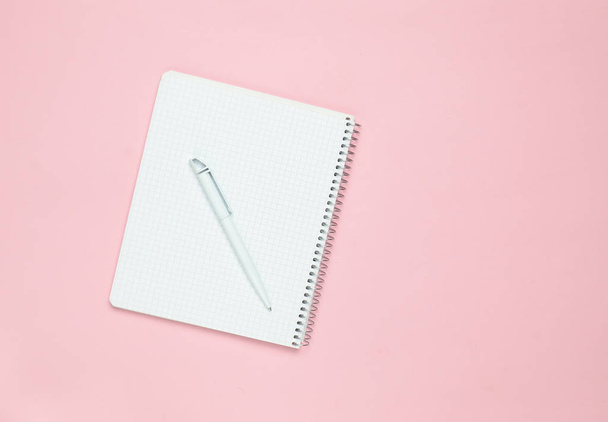 ピンクのパステル調の背景、平面図、ミニマリズム トレン ペンとメモ帳 - 写真・画像