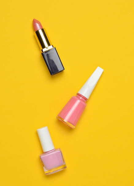 Women's cosmetics and accessories for beauty care on a yellow pastel background. Nail polish, lipstick, top view, minimalist tren - Foto, Imagem