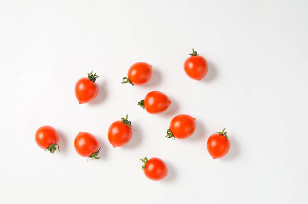 A lot of ripe mini cherry tomato on a white backgroun - 写真・画像