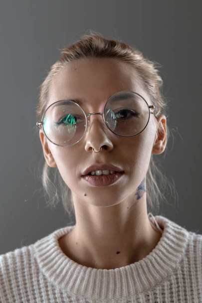 Emotionele portret van een meisje met bril en een trui - Foto, afbeelding