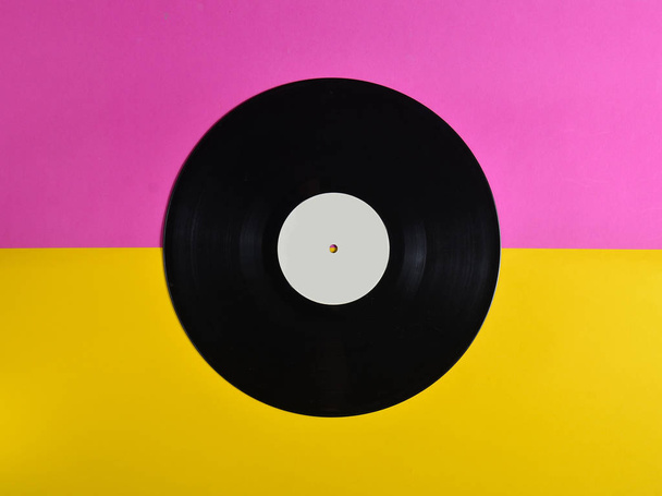 Vinyl plate on a colored pastel background, retro music technology, top view, minimalis - Fotografie, Obrázek
