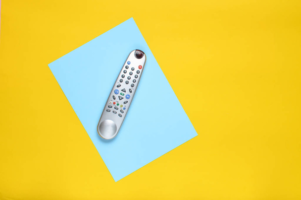 TV remote na pozadí modré žlutého papíru. Pohled shora. Minimalismu. Kopírovat spac - Fotografie, Obrázek