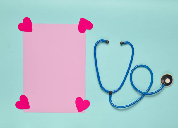 Medische geschiedenis blad met decoratieve harten, stethoscoop op een gekleurd papier achtergrond. Medische concept. Bovenaanzicht - Foto, afbeelding