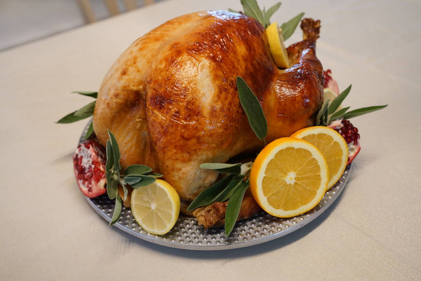 roasted turkey on dish with herbs, pomegranate and citrus slices - Фото, изображение