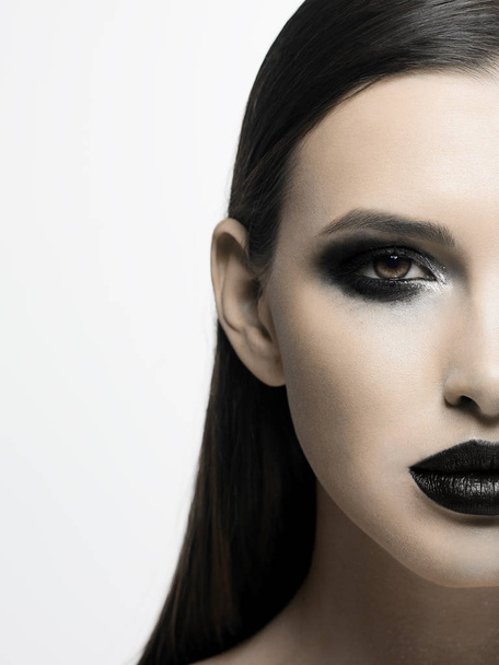 Black and white photograph of the terrible beauty of the model, like from a horror movie. Party party, Halloween, creative make-up, smoky eyes and full lips - Fotoğraf, Görsel