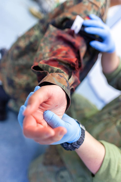 Un soldat ambulancier soigne une fracture du maquillage
 - Photo, image