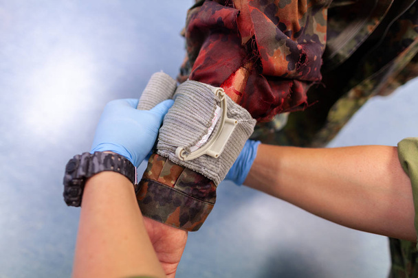 Paramedic soldier creates a bandage on a make up fracture - Fotografie, Obrázek