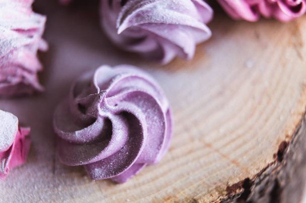 Close up of homemade cut pink zephyr or marshmallow in powdered sugar on wooden. Black currant, blueberry marshmallows. - Fotoğraf, Görsel