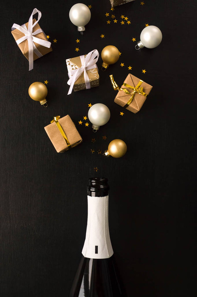 Şampanya şişesi siyah arka plan üzerine farklı Noel dekorasyonu ile. Yeni yıl kavramı. Düz yatıyordu. - Fotoğraf, Görsel