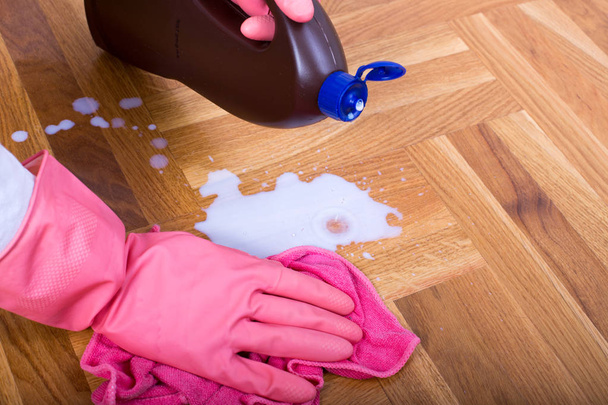 Primo piano della mano femminile con guanti protettivi pulire pavimento in parquet
  - Foto, immagini
