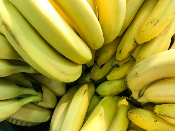 Hermoso amarillo natural dulce sabroso maduro suave redondo grandes plátanos brillantes. Textura, fondo
 - Foto, imagen