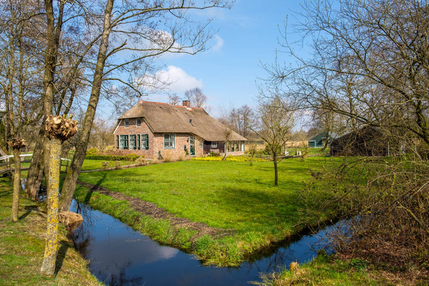 Νωρίς την άνοιξη Δες στο Giethoorn, Ολλανδία, ένα παραδοσιακό ολλανδικό χωριό κανάλια παντού, με όμορφα ρουστίκ ψάθινη οροφή σπίτια αγρόκτημα - Φωτογραφία, εικόνα