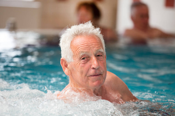 Anciano disfrutando en piscina con agua caliente en balneario
 - Foto, Imagen
