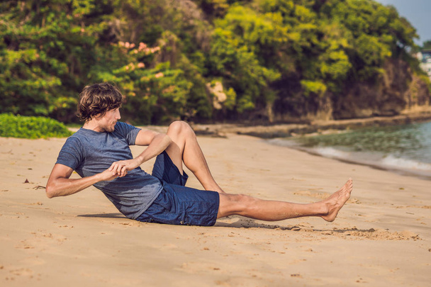 молодой мужчина тренируется на пляже, спортивный человек делает упражнения
 - Фото, изображение