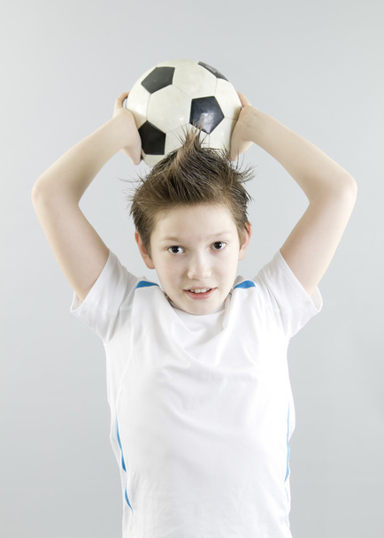 Boy in white t-shirt with football ball - 写真・画像