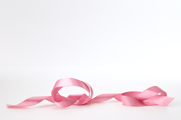 Gekruld roze lint op witte achtergrond, lege ruimte voorontwerp - Foto, afbeelding